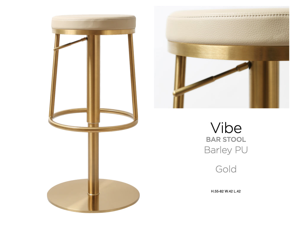 Bar stool with gold frame and beige cushioned seat on a white background. Vibe bar stool by House of Murphy