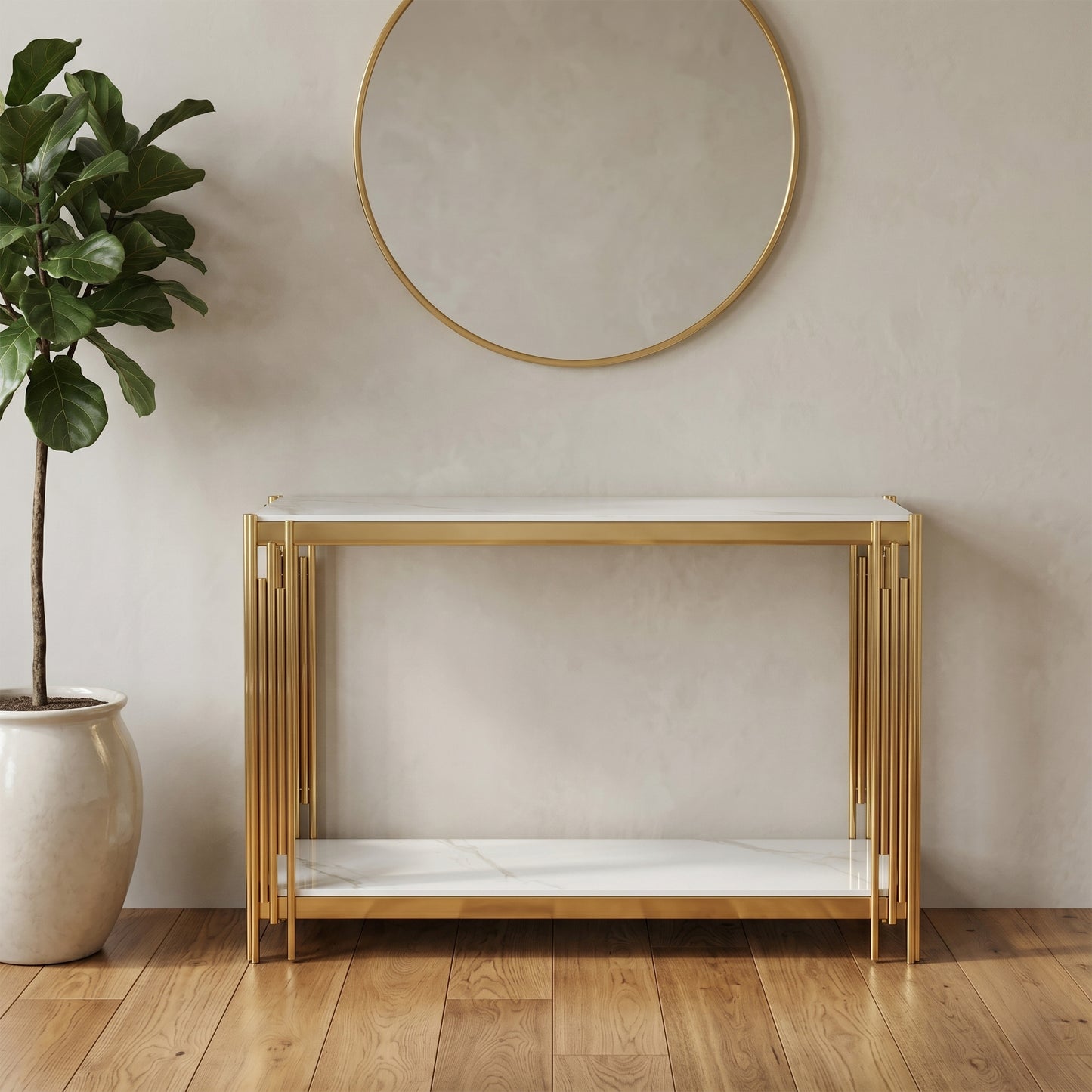 A modern console table with a white marble-look top and bottom shelf, supported by a gold-finished metal frame with vertical slat details, set against a textured beige wall with a round mirror and a potted plant. Belini Gold console by House of Murphy