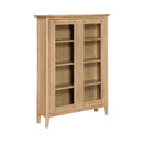 Switch A light natural oak wood display cabinet with two glass doors, four interior shelves, and small round knobs, shown on a plain white background. 2 image