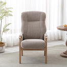 Switch A high-back upholstered accent chair with a textured taupe-beige fabric and light natural wood frame, set in a bright room with sheer white curtains, a potted fern, and a wooden side table. 2 image