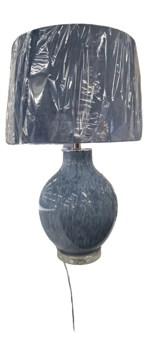A blue glass table lamp with a textured ceramic base and a matching blue fabric drum shade  by House of Murphy