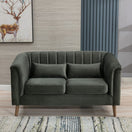 Switch A dark green velvet loveseat sofa , two matching throw pillows, and light wood legs, shown in a styled living room setting. 2 image